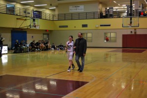 Photo by Bini Allen. Senior Alex Sher is walked down the Rams' home court by her dad.