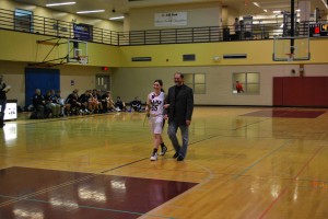 Photo by Bini Allen. Senior Alex Sher is walked down the Rams' home court by her dad.
