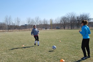 Photo by Hannah Pinson. Junior Moriah Abrams and Coach Rebecca Glueck demonstrate the correct way to pass the ball. 