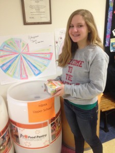 Photo by Zach Kriesler. Sophomore Elana Goldenberg donates a box of pasta during the food drive.