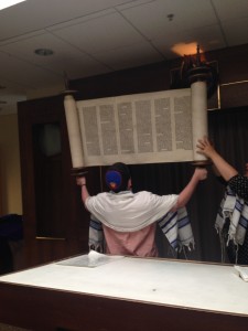 Photo by Adena Goldberg. Sophomore Sam Matsil shows off his strength as he lifts the Torah.