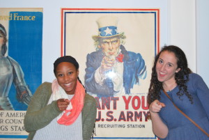 Juniors Ella Pavin (left) and Adena Goldberg pose in front of a poster in the museum. Photo by Moriah Abrams