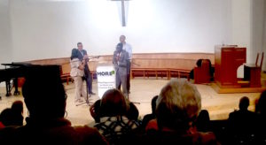 Third District Councilman Jermaine Reed (right of podium), called up by Criminal-Justice Task Force co-chairs Rabbi Kiku Brooks (far left) and David Alpert (left), addressed the audience at a MORE2 annual event: “It’s gonna take all your voices- all your advocacy- all of you to raise the bar or everyone in this city” Photo by Haidee Clauer 